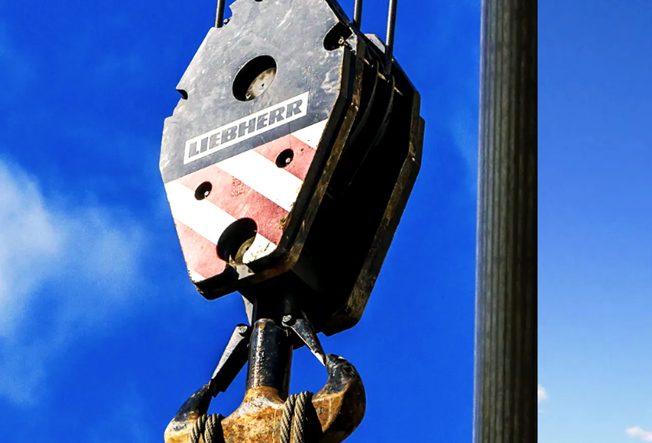 Crane hook block against a blue sky